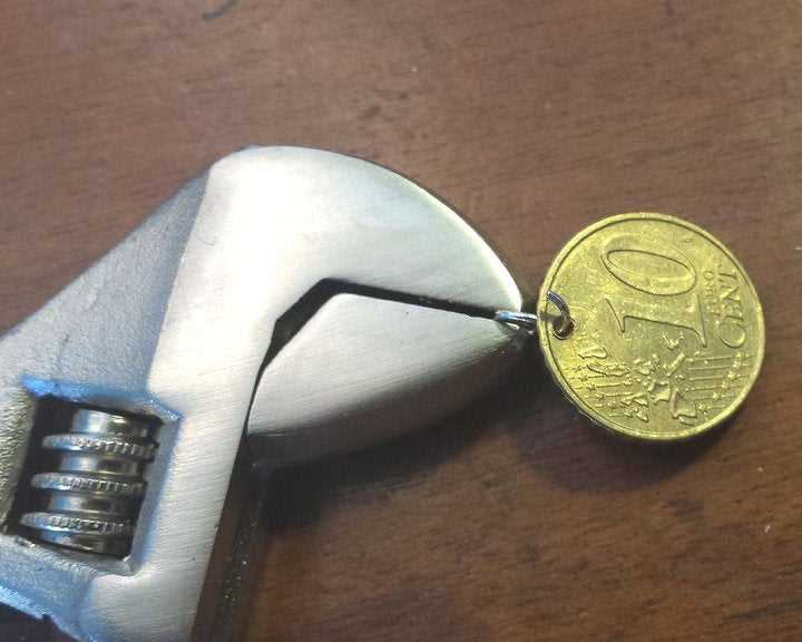 How to Make a Hole in a Coin Without Using a Drill Method 4: Using a Metal File